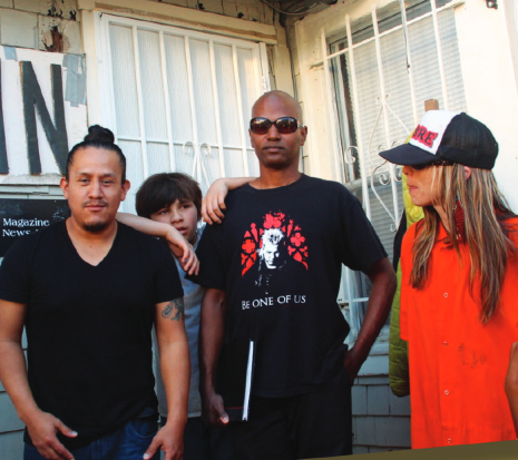 group of people is staing on the front of POOR Magazine office 