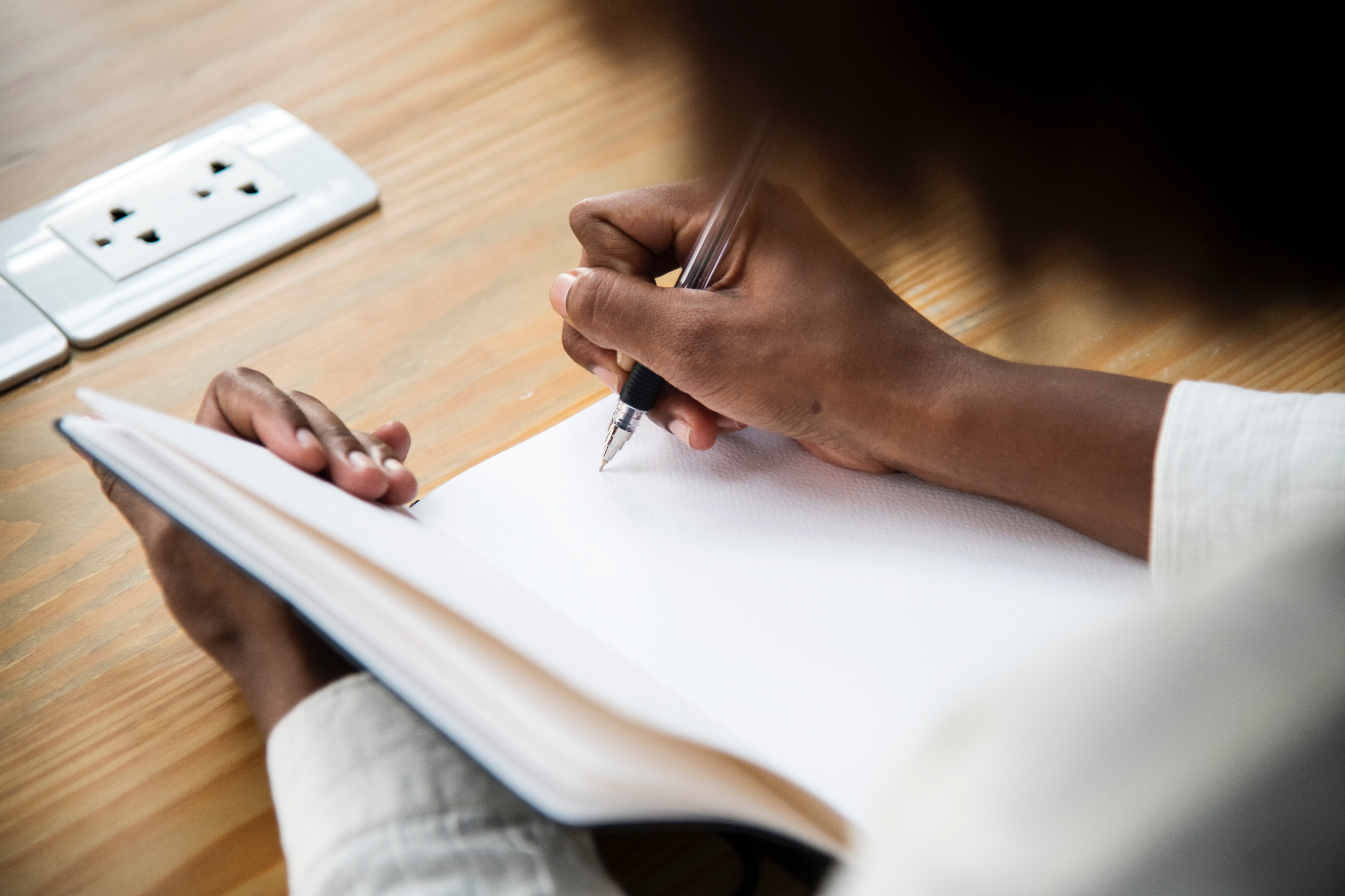 woman writing in a blank book 