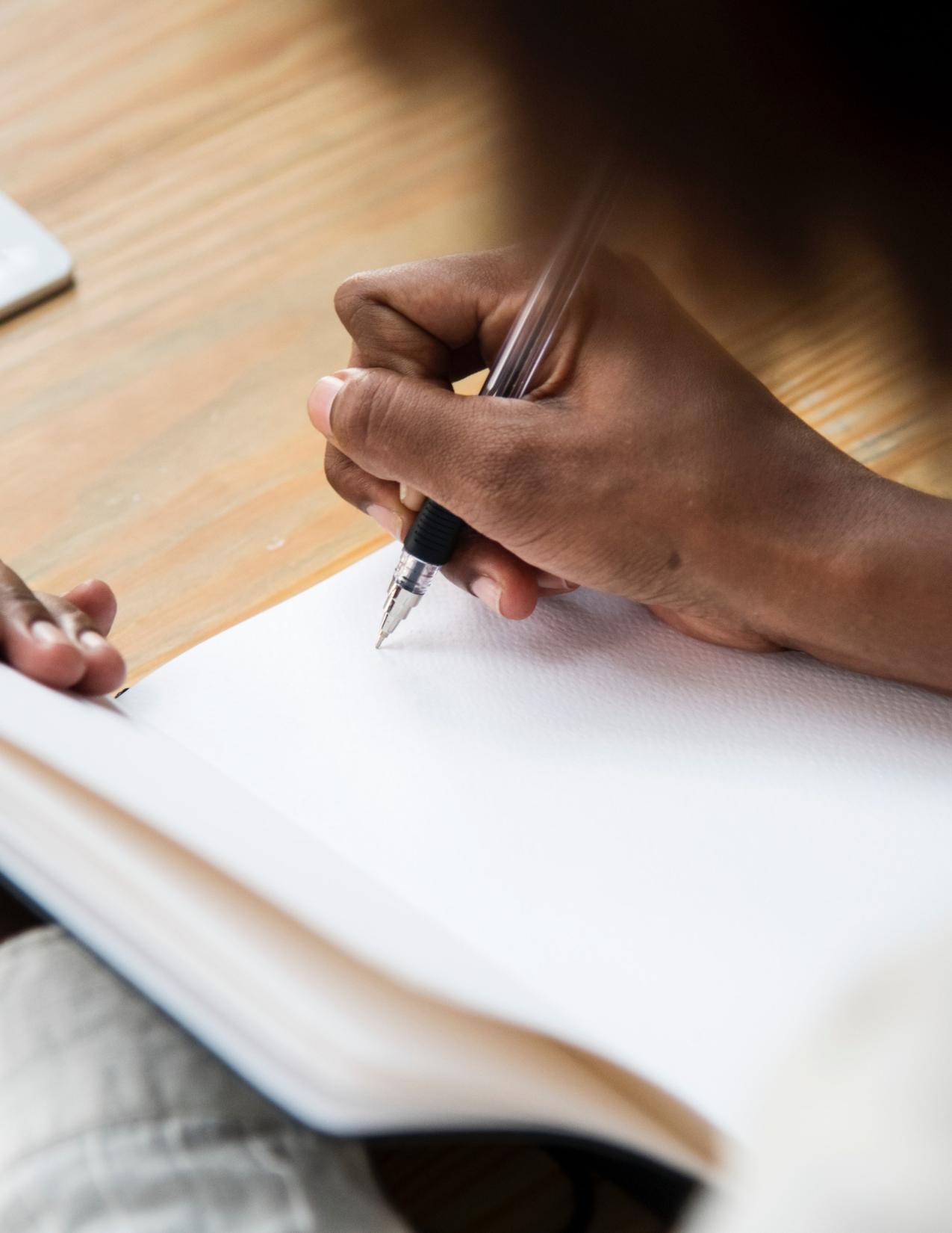 woman writing in a blank book 